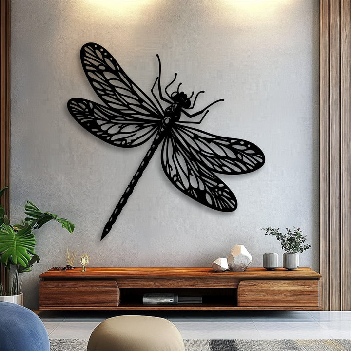 Against a pale, textured grey wall, an elegant black dragonfly unique metal wall art piece creates a striking focal point.