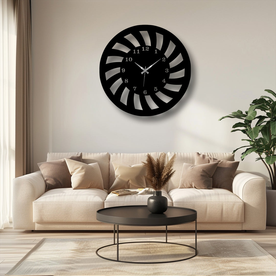 The organic forms of this captivating spiral motion metal artwork wall clock feature dynamic, curved black blades on a light wall.