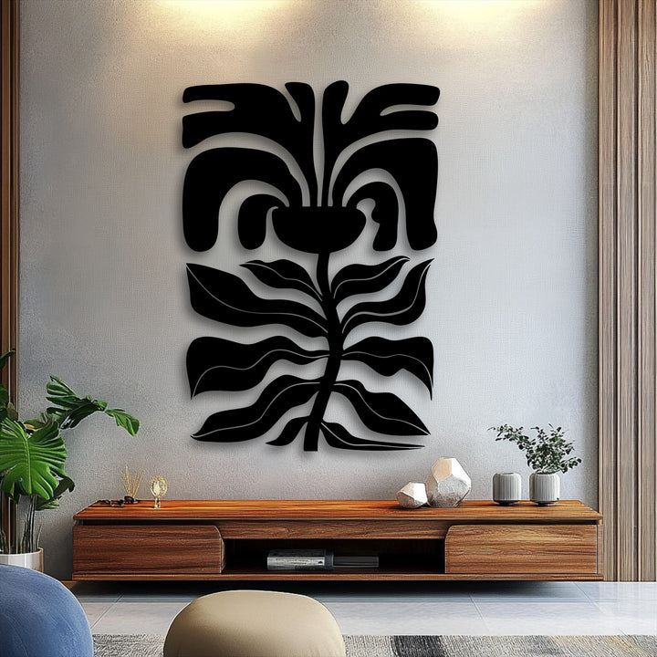 The striking contrast of the black abstract floral face metal wall decor against the subtly textured light grey wall creates a defined color transition.