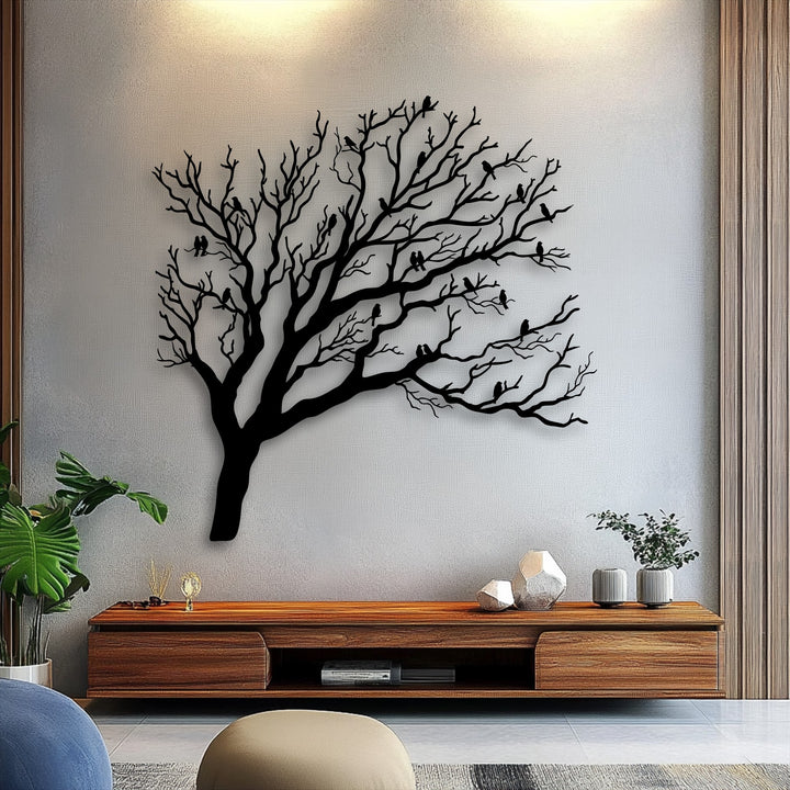 The light gray wall highlights the unique metal wall art, a nature silhouette of birds on bare tree branches.