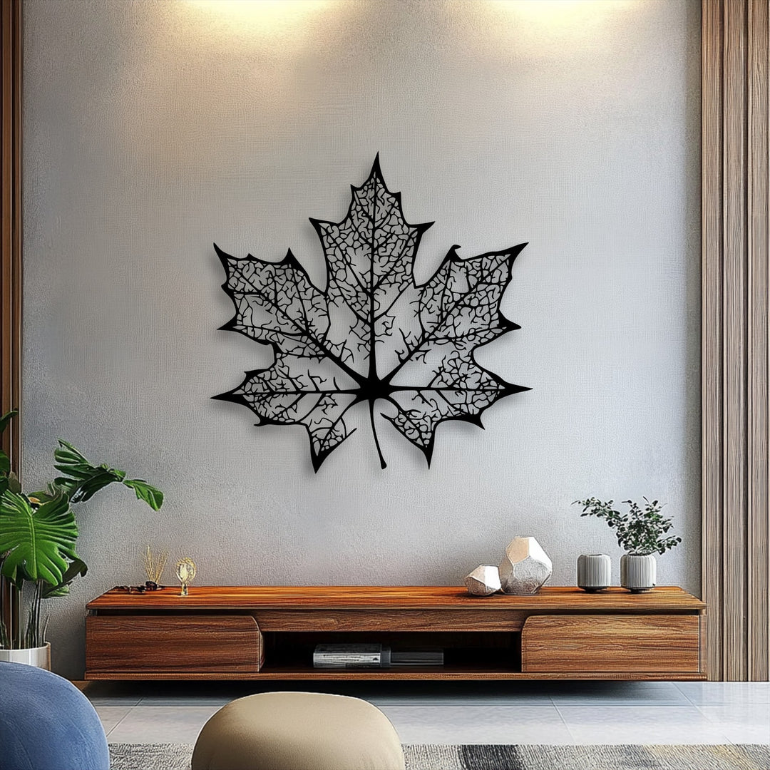 The layering effect of this intricate maple leaf metal artwork is highlighted by the shadows it casts on the textured wall.