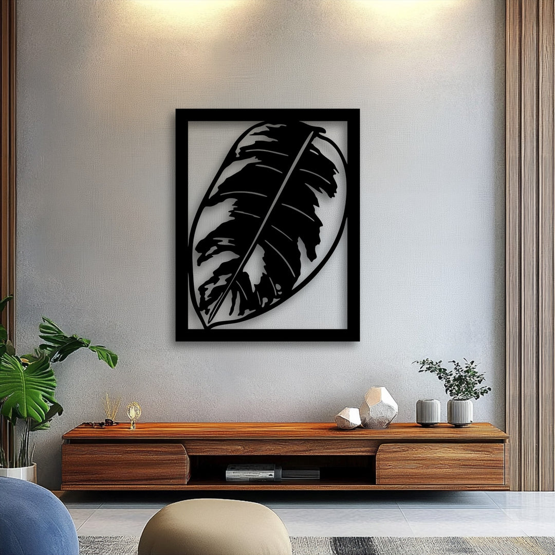 Showcasing varied surface textures, the subtle wall pattern highlights a sleek, matte black Monstera Leaf metal art for wall and warm wood grain.