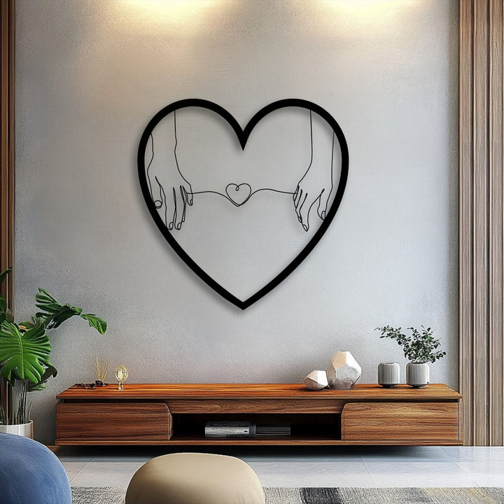 Ambient light and deep shadows define the connected hearts holding hands in this minimalist love decorative metal art piece.