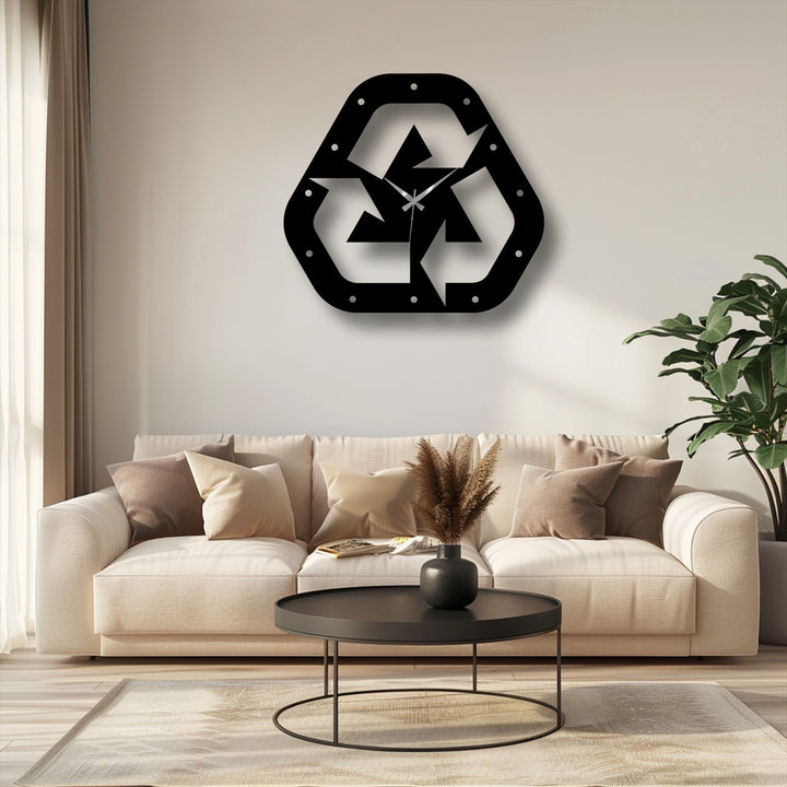 Foreground detail showing a round black coffee table with a simple vase, blending seamlessly with the modern home decor complementing the recycle symbol metal wall clock.