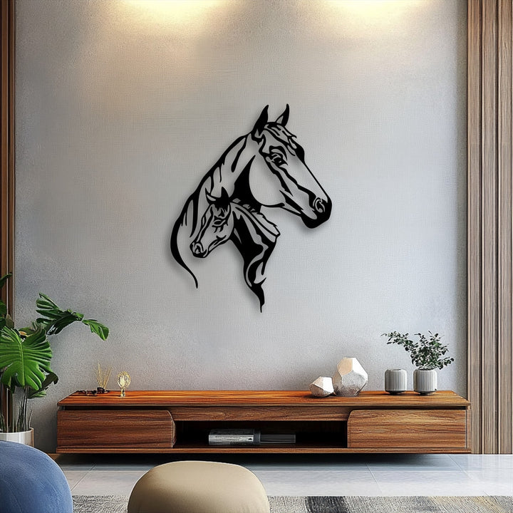 The brightest area reveals a warm glow on a textured wall, highlighting the elegant Dual Horse Head Silhouette unique metal wall art.