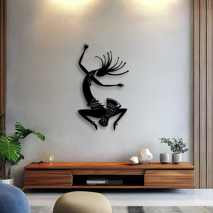 The striking Tribal Dance Silhouette metal wall decor creates compelling depth, casting dynamic shadows upon the textured wall.