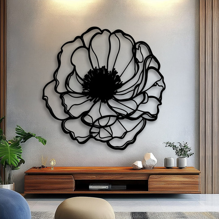 The focal point is a prominent black elegant bloom outline metal wall decor against a textured light gray wall.
