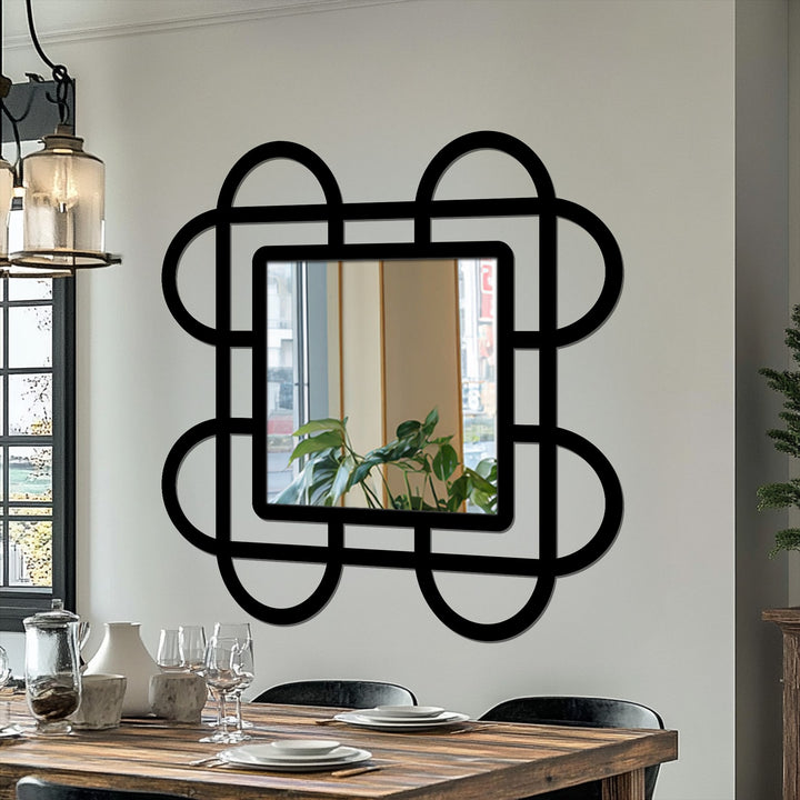 The stillness captures the looped squares geometric wall bathroom mirror, its rounded black frame reflecting a serene tableau in a dining space.