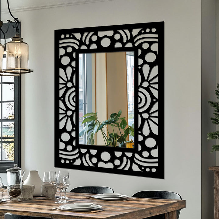 Intricate depth and layers are created in this art deco decorative mirror featuring a black metal frame with a repeating floral pattern and geometric detail.
