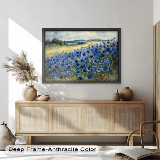 The focal point showcases a framed oil painting art piece featuring golden fields and blue cornflowers, depicting an impressionist meadow scene with summer warmth.