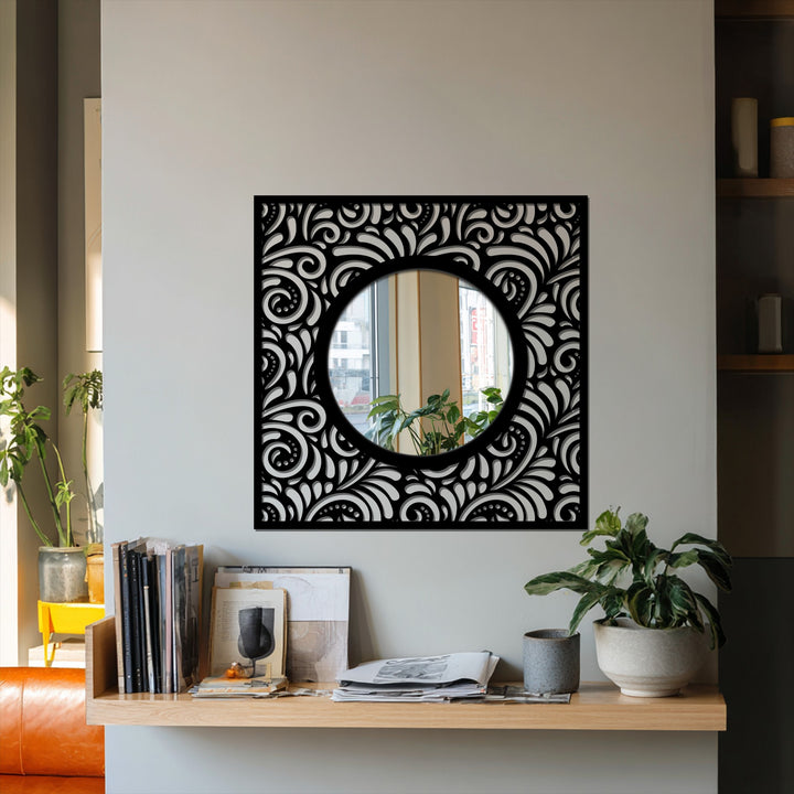 Textured surface of the ornate eclipse mirror for wall decor reveals a decorative black metal patterned frame around the round mirror.