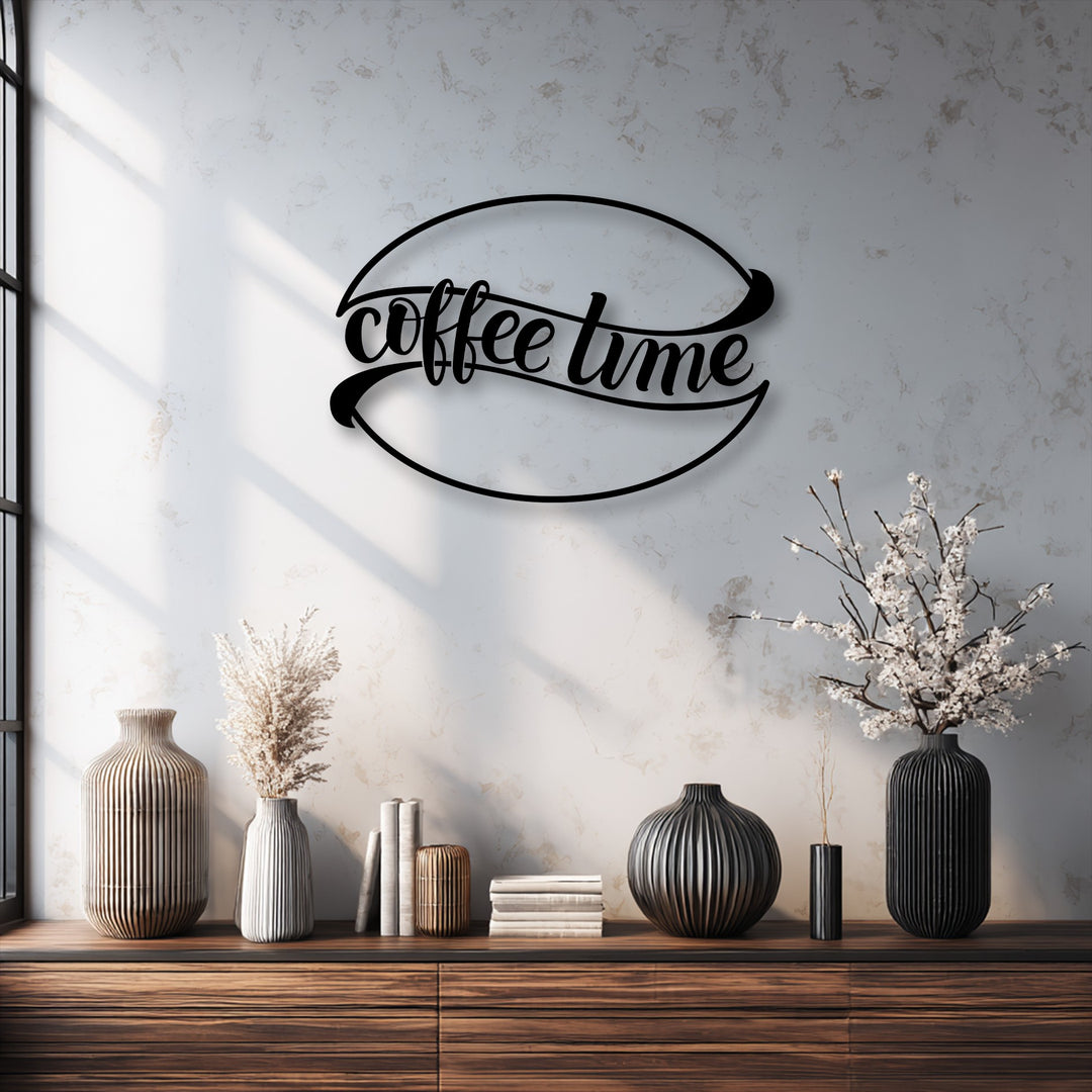 A creamy white wall showcasing a black coffee time metal wall decor sign above a wooden table with ribbed vases.