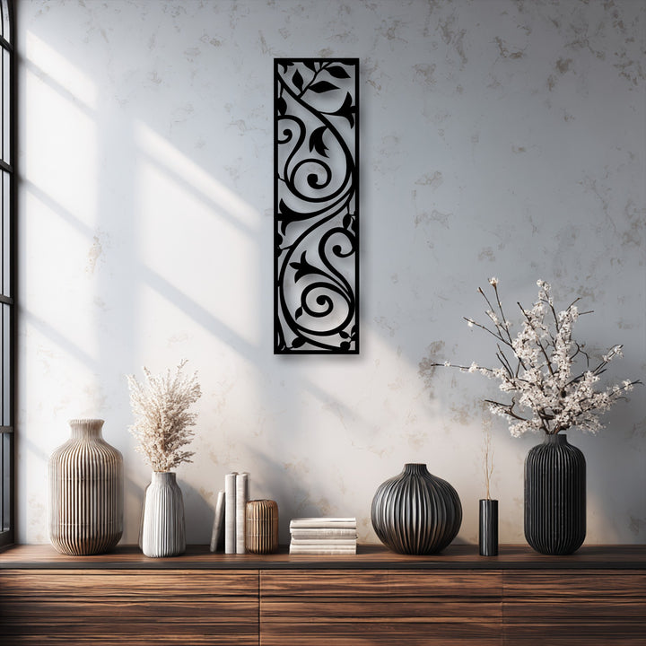 The delicate white blossoms in the fluted vase softly contrast with the striking elegant scroll vine decorative metal art panel on the textured wall.