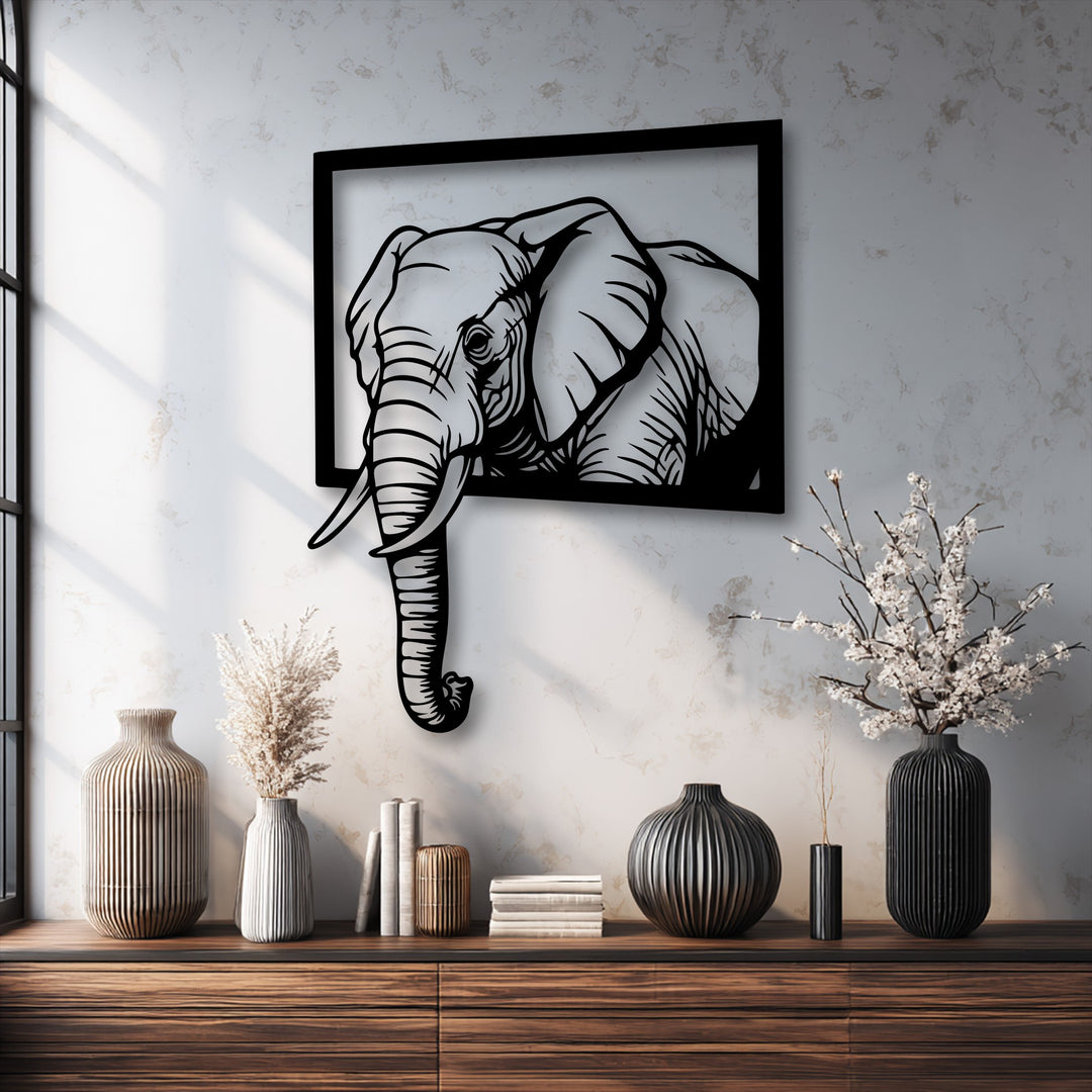Sunlight illuminates the bright white wall, highlighting the bold black Emerging Elephant Frame metal wall decor with a striking 3D effect.