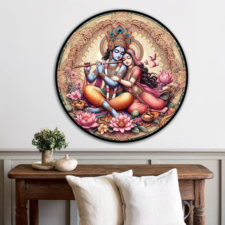 Foreground shows plush white pillows beneath a rustic wooden table, enhancing the presentation of the divine Radha Krishna oil painting artwork above.