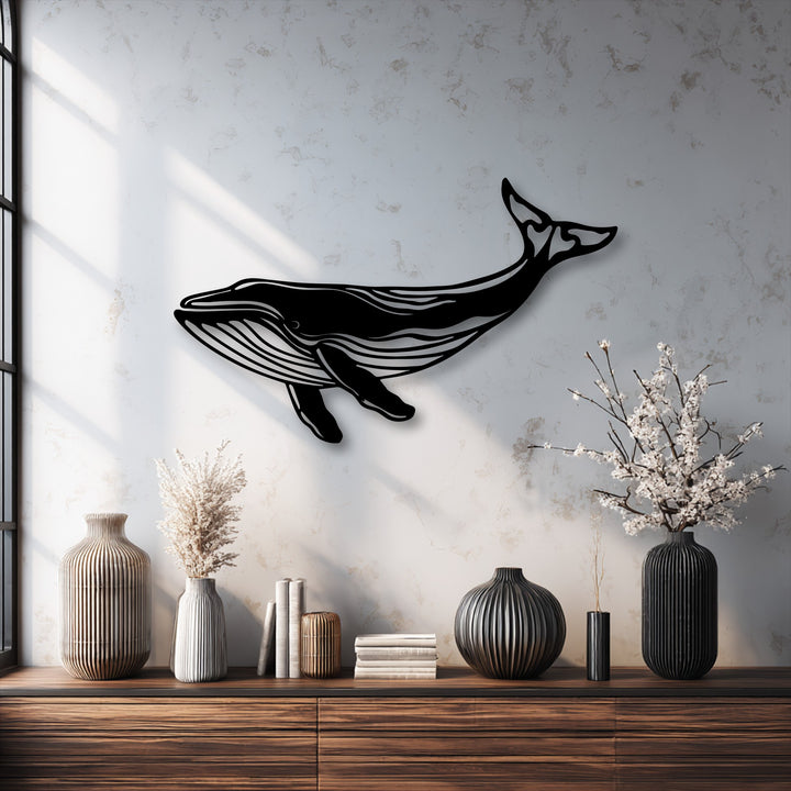 The subtly textured white wall beautifully contrasts with the smooth, matte surface of the majestic whale silhouette decoration wall art.