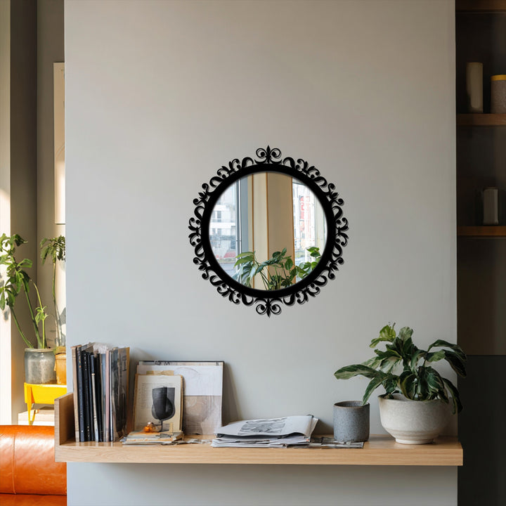 Highlighting the layering effect, this ornamental round mirror showcases how decorating with wall mirrors creates depth above a shelf of books and a lush houseplant.
