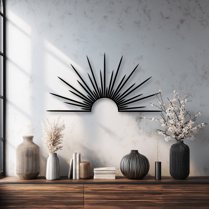 A minimalist black metal sunburst piece creates a striking focal point, serving as elegant metal wall decor above a wooden console.