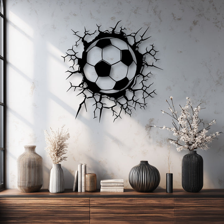 Delicate white blossoms stand gracefully, contrasting with the dynamic Breaking Wall Soccer Ball decorative metal art on the textured wall.