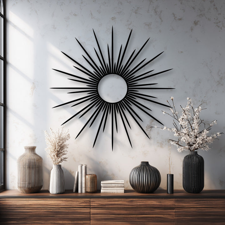 The brightest area of the wall is beautifully illuminated, highlighting the striking black decorative metal art with its radiant sunburst design.
