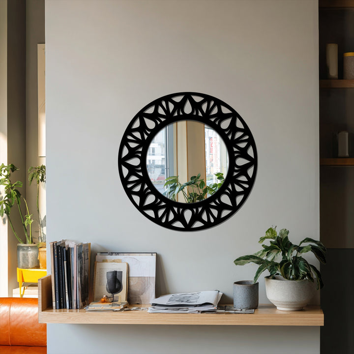 Organic forms shape the floral cutout on this round floor mirror, a modern black metal wall decor piece that adds statement design to any space.