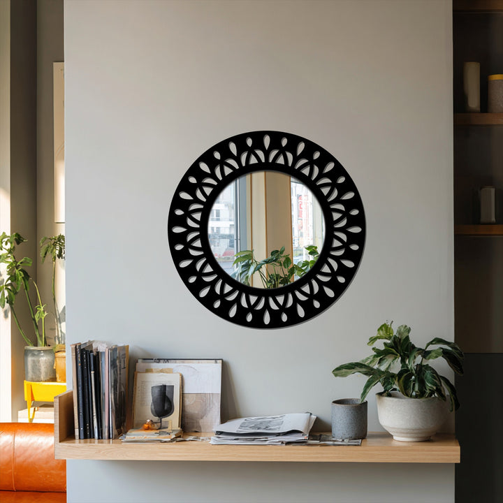Sunlight casts intricate shadows through the black metal leaf motif mirror for wall decor, highlighting its decorative design.