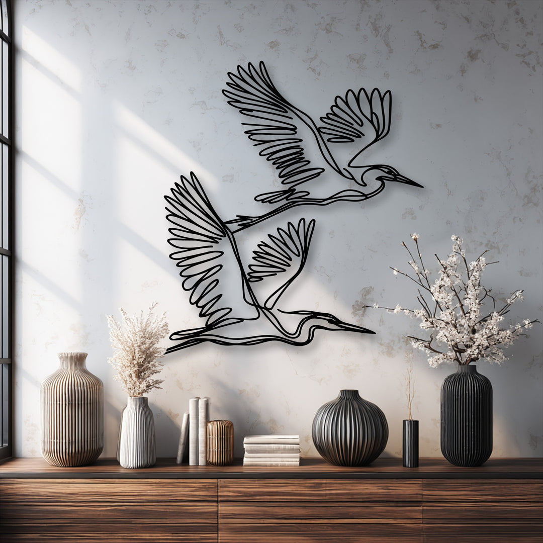 Graceful minimalist black outline herons form elegant metal art for wall decor against a subtly textured light gray background.