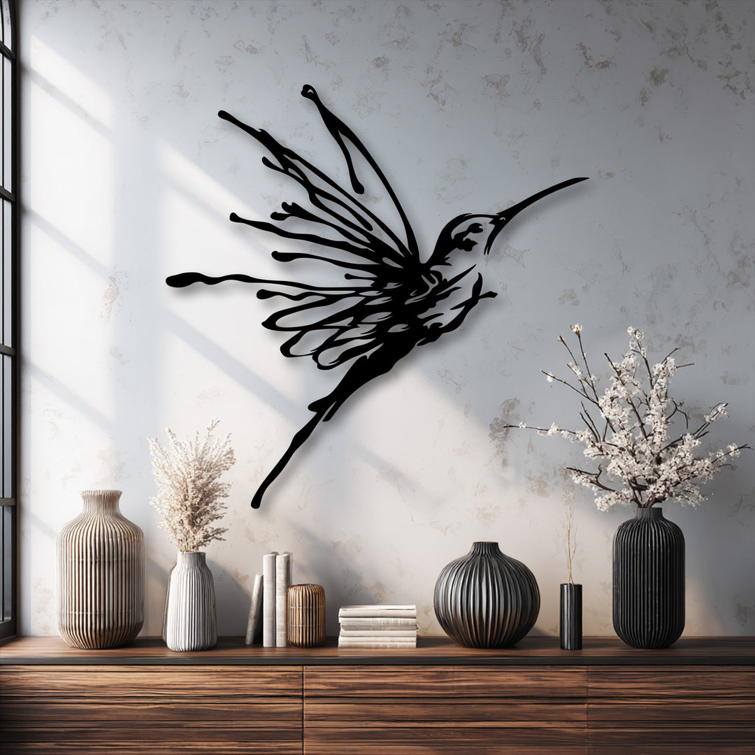 Light beige walls showcase an elegant black flying hummingbird metal art for wall, displayed above a wooden console table.