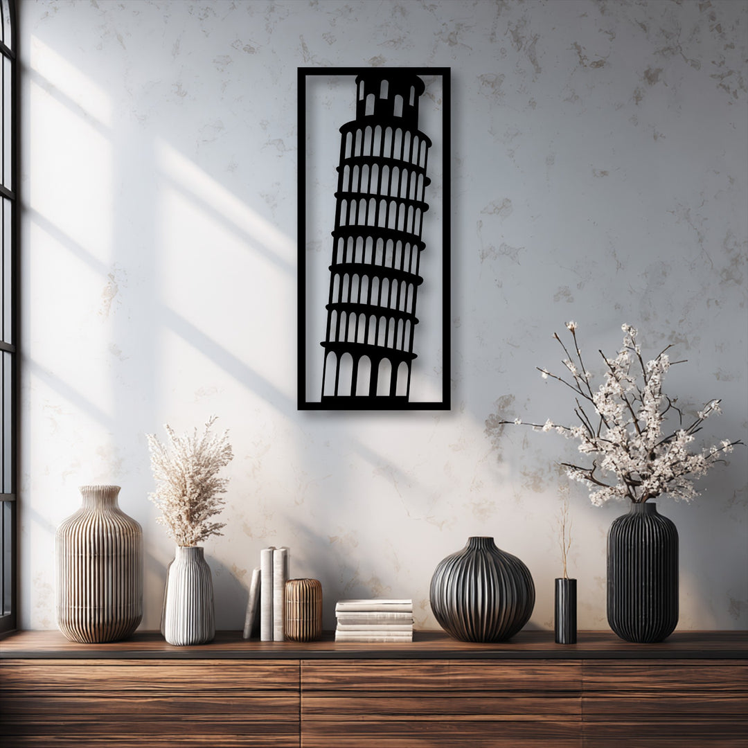 A vertically oriented, rectangular unique metal wall art piece features the distinct leaning silhouette of the Leaning Tower of Pisa.