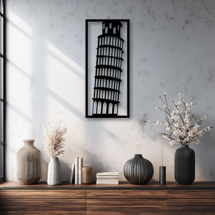 A vertically oriented, rectangular unique metal wall art piece features the distinct leaning silhouette of the Leaning Tower of Pisa.