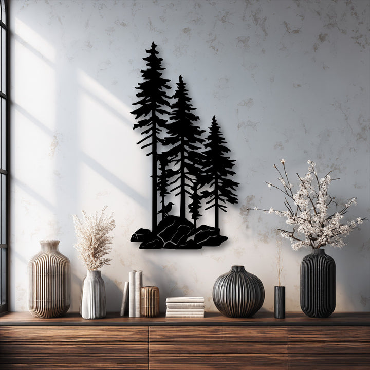 The subtle shift from bright sunlit white to muted grey-beige wall tones highlights the striking forest pine trees decorative metal art silhouette.