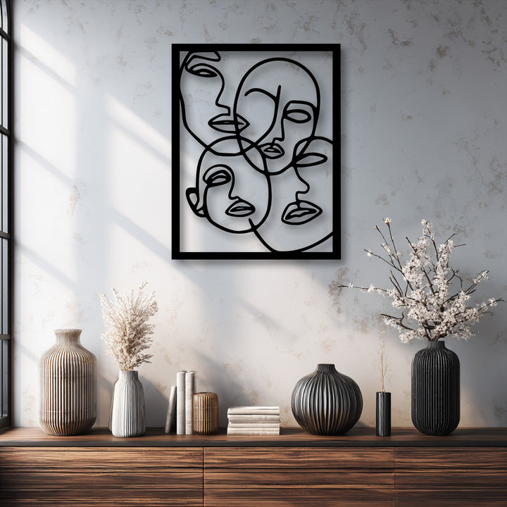 The darkest area highlights the sleek black frame and abstract line art faces of the metal art for wall, displayed above a deep wooden cabinet.