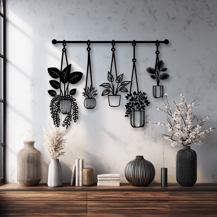 The striking black metal artwork of five botanical hanging plants dramatically stands out against a textured wall.