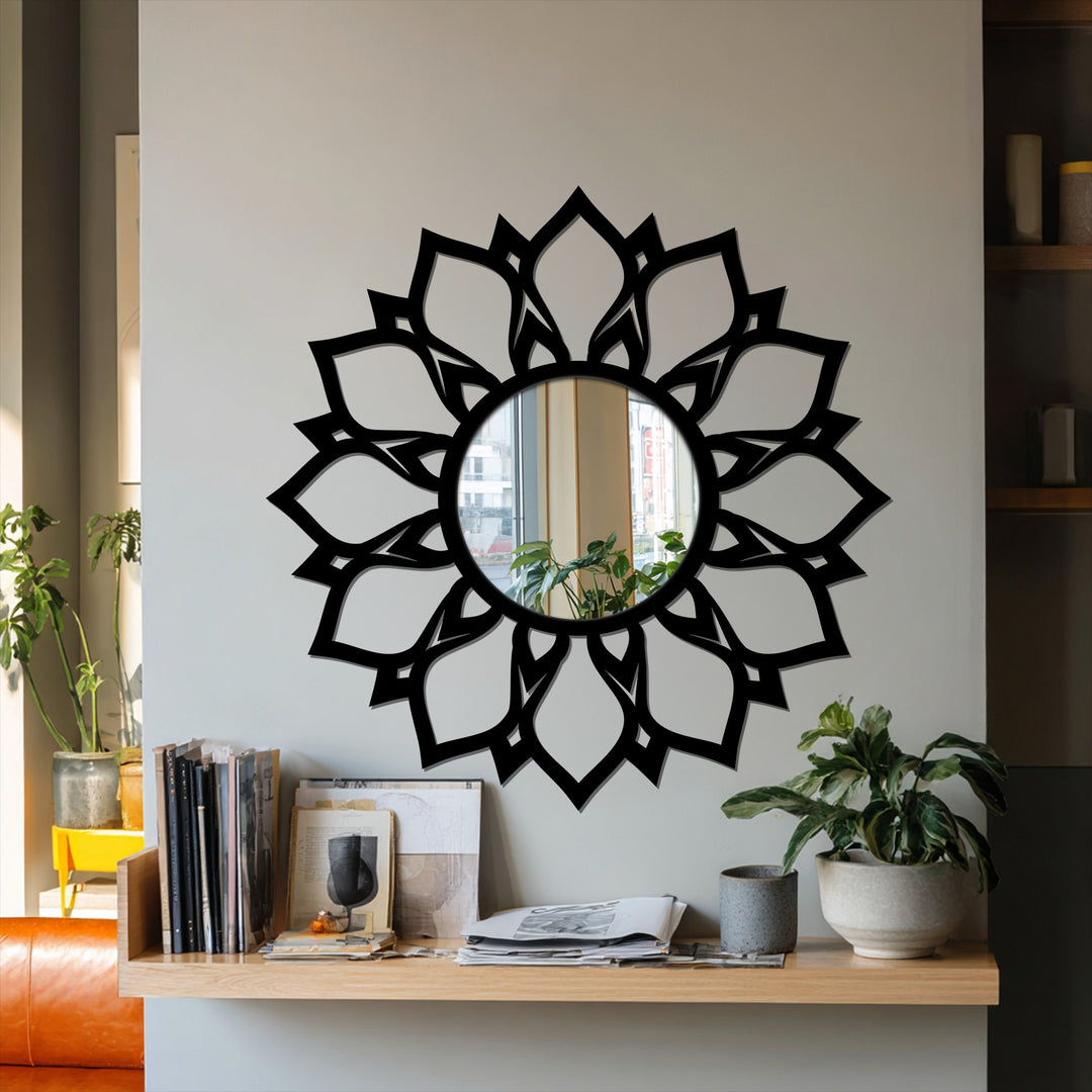 Neutral color temperature highlights the elegant lotus pattern and its black metal artwork frame in the framed wall mirror reflecting an indoor space.