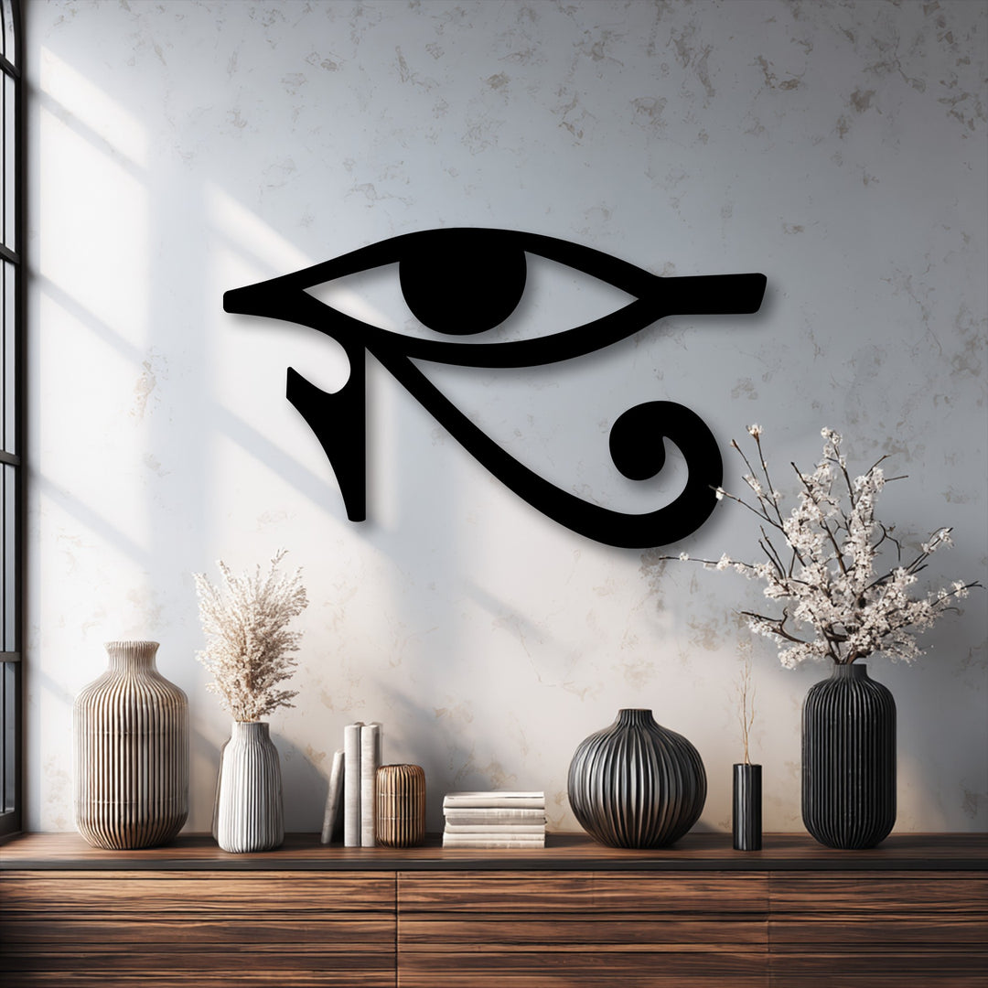 Delicate white blossoms in a ribbed black vase stand near an Eye of Horus metal wall decor, contrasting with the ancient Egyptian symbol.