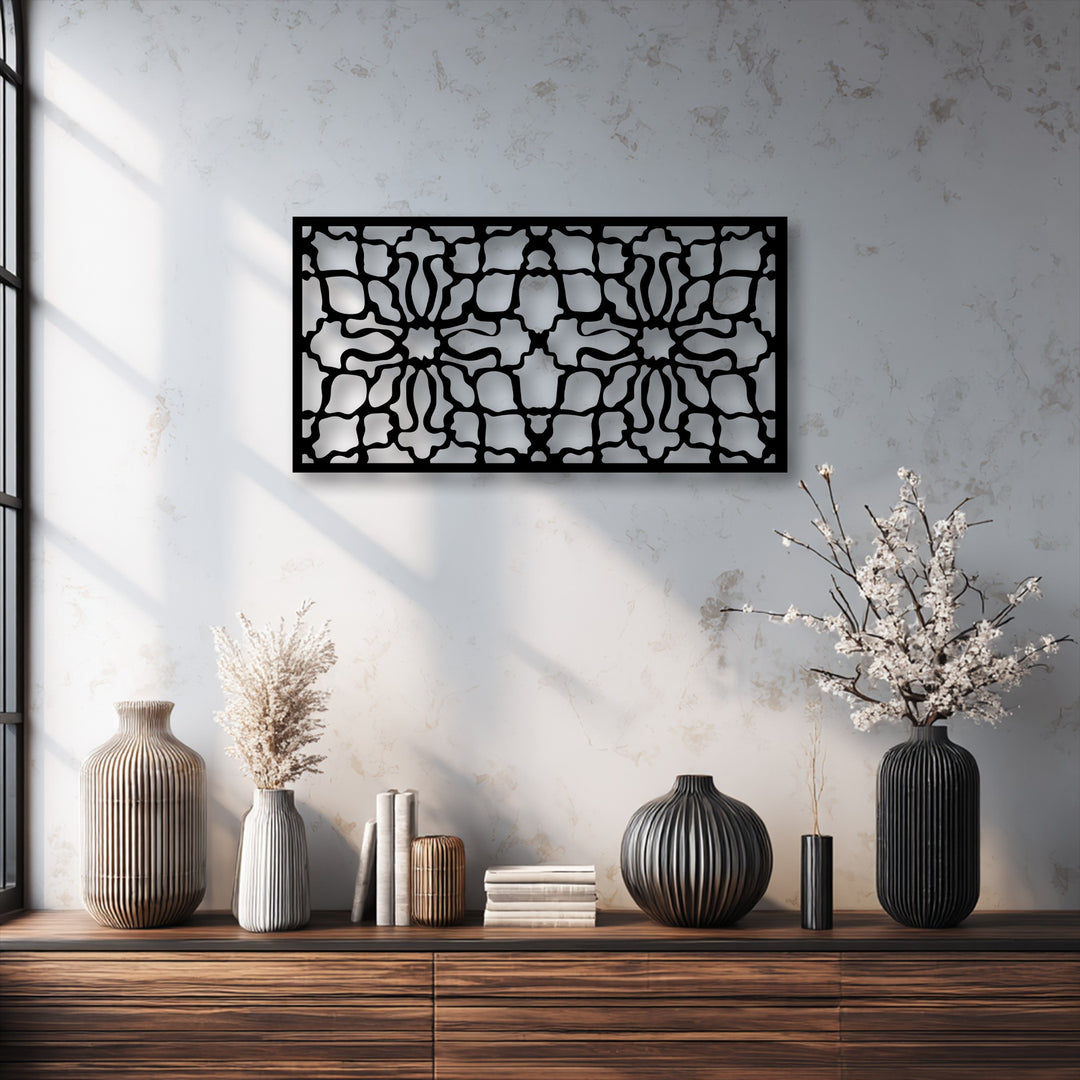 A stylish dark wood console table displays various ribbed vases in earthy tones and stacks of books, with decorative metal art on the wall above.
