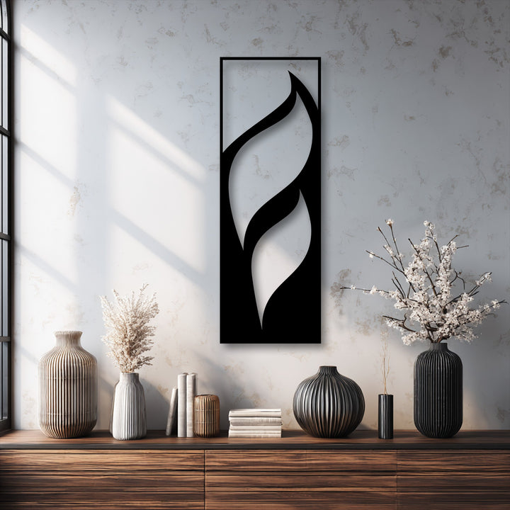 Dramatic contrast of the black flowing leaves metal artwork creates a visual transition of colors against the bright, textured wall.