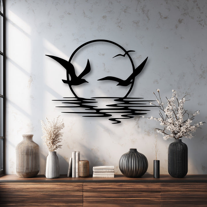 The focal point is the elegant black metal artwork depicting soaring seagulls silhouetted against a serene sunset and stylized ocean reflections.
