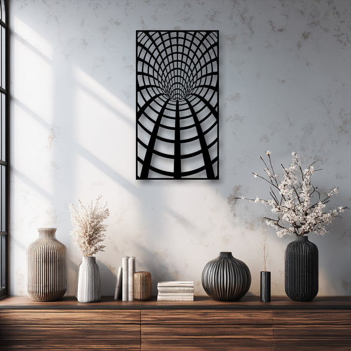 The dark wooden console table in the foreground displays ribbed vases, books, and dried plants, complementing the unique metal wall art.