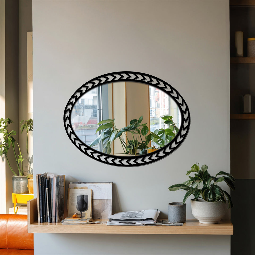 Chevron-patterned decoration wall art defines this oval floor mirror, reflecting a plant-filled windowsill and adding a touch of modern geometric design.