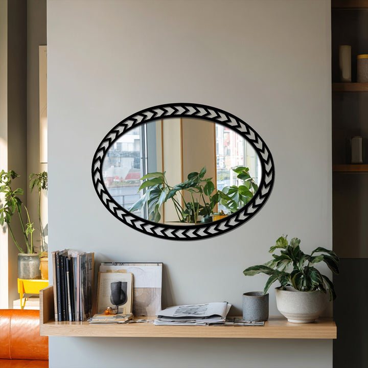 Chevron-patterned decoration wall art defines this oval floor mirror, reflecting a plant-filled windowsill and adding a touch of modern geometric design.