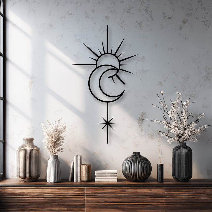 A striking black celestial sun and moon decorative metal art piece with a minimal star line design is mounted on a textured white wall.