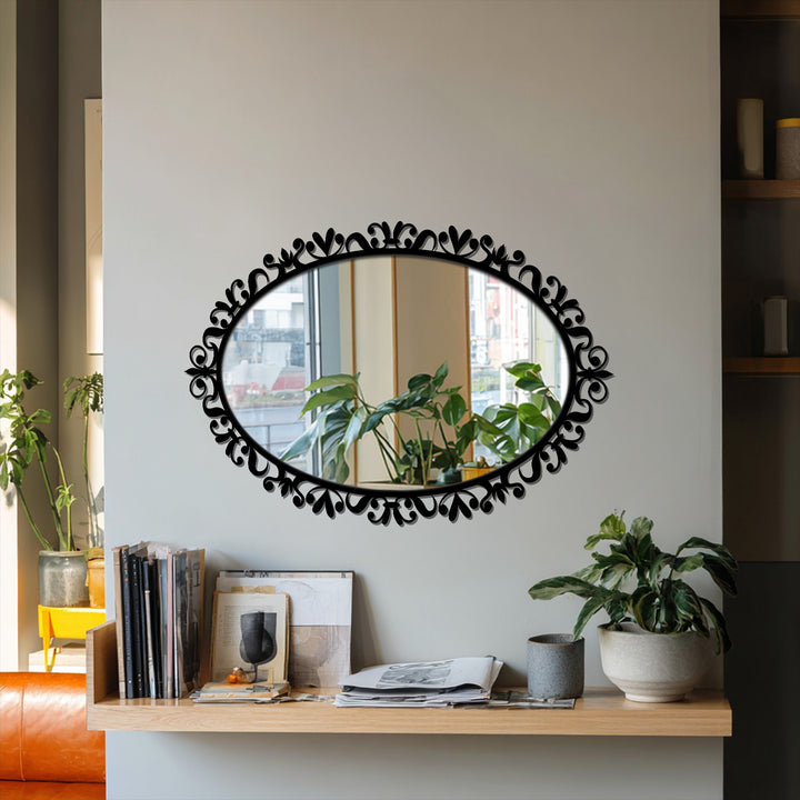Subtle light and shadow play across the wall, enhancing the ornate scrollwork metal frame of this decorative oval modern mirror.