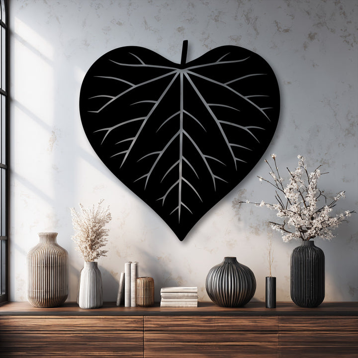 This stunning, vertically oriented heart-shaped leaf silhouette is a captivating piece of black metal wall decor.