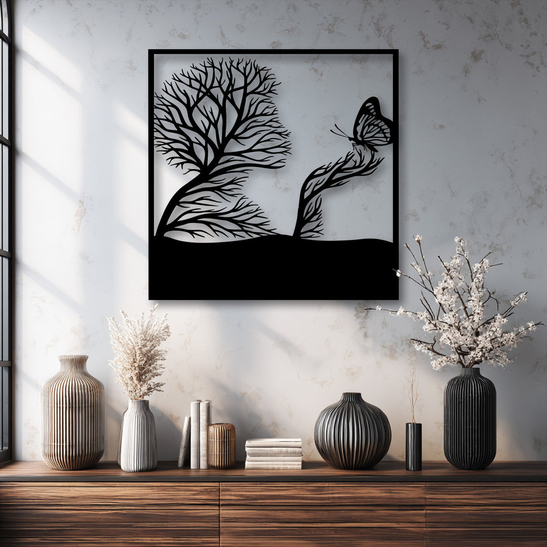 The striking black silhouette of whimsical tree and butterfly artistic nature metal wall decor hangs prominently over a rustic wooden dresser.