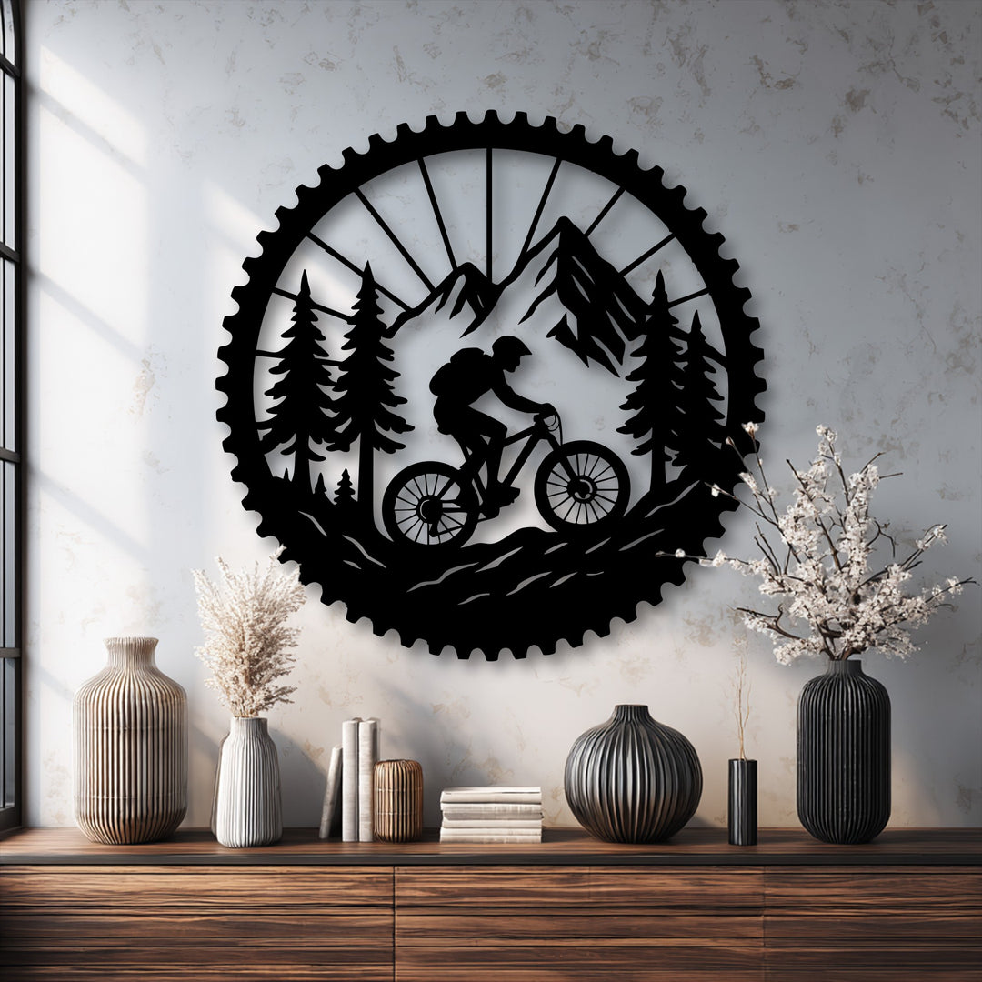 The brightest area highlights the detailed trail rider mountain bike adventure metal artwork, showcasing a rider traversing mountains and pine trees.