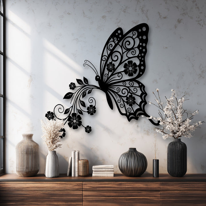 The elegant black butterfly metal wall decor with intricate floral patterns creates a graceful sense of upward movement on the textured wall.