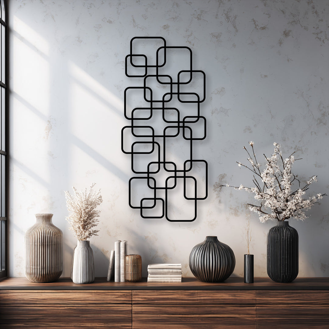 The fluffy texture of dried pampas grass and delicate white blossoms provide a soft counterpoint to the striking geometric decorative metal art.