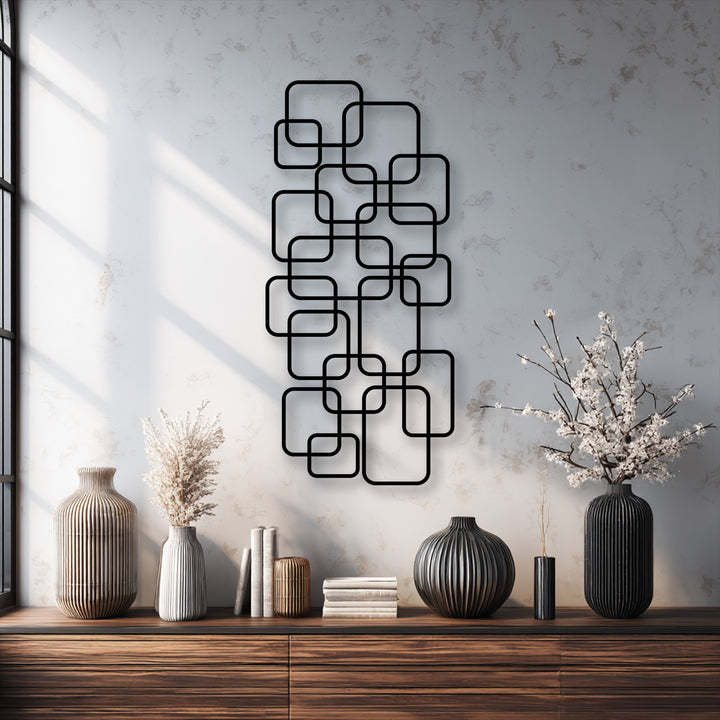 The fluffy texture of dried pampas grass and delicate white blossoms provide a soft counterpoint to the striking geometric decorative metal art.