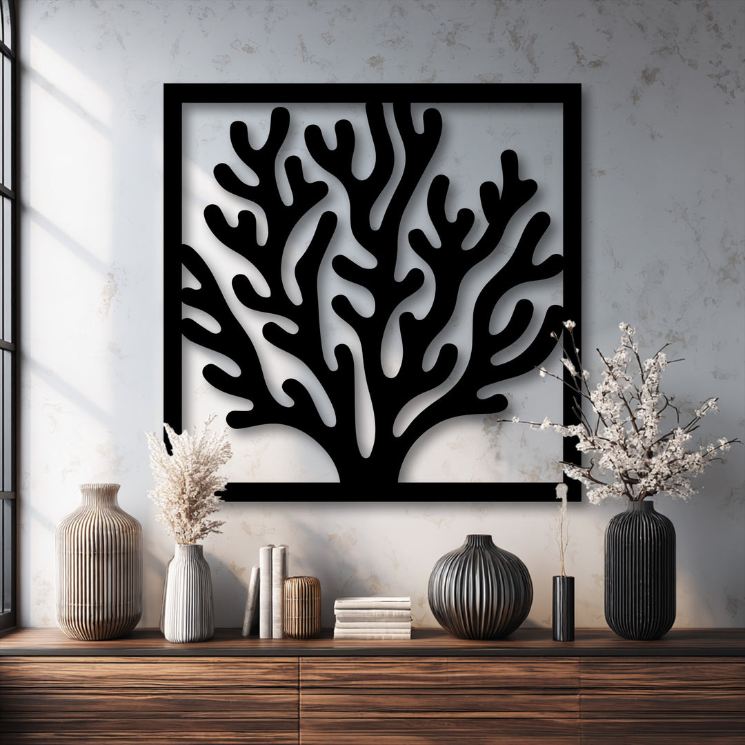 The brightest area, the textured white wall, highlights the dark, intricate unique metal wall art of a coral frame.